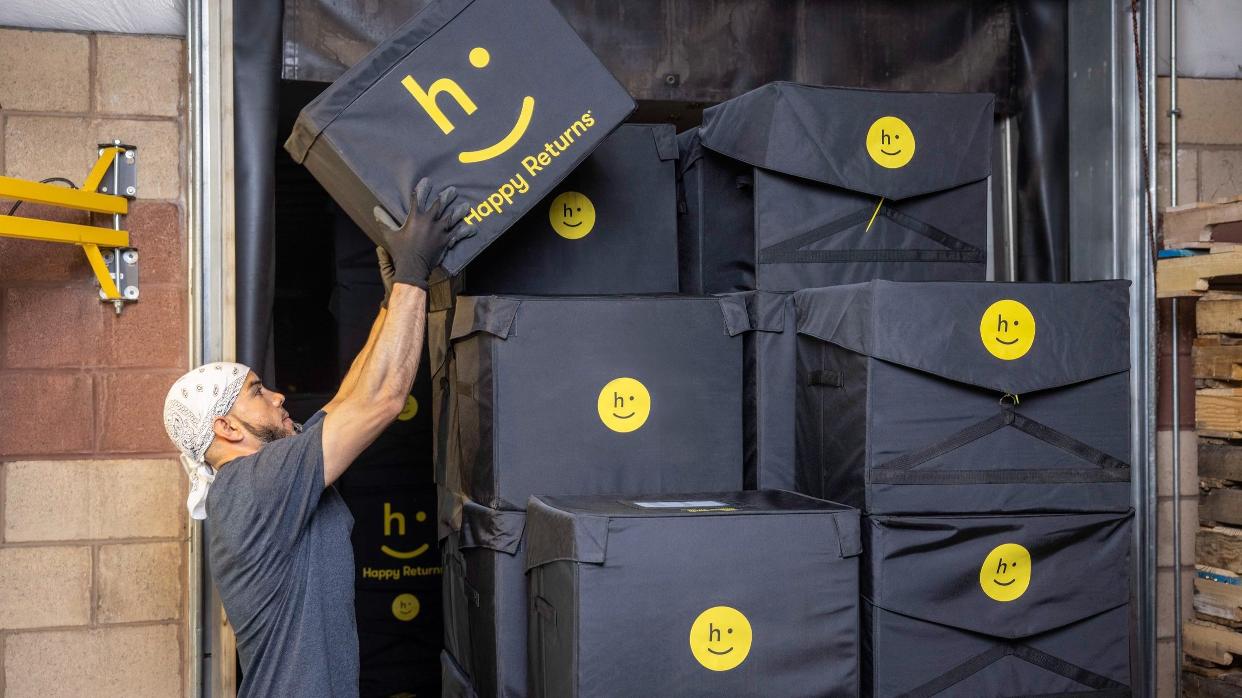 Hub warehouse employee stacking reusable totes for transfer